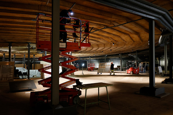 Ein Arbeiter montiert die Halteseile für die Bildaufhängung.