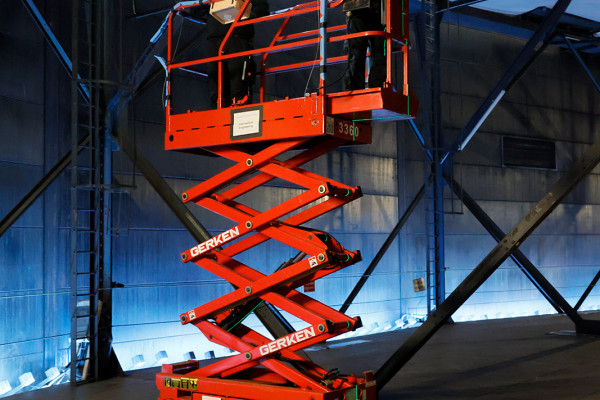 Zwei Arbeiter auf einem Hubwagen