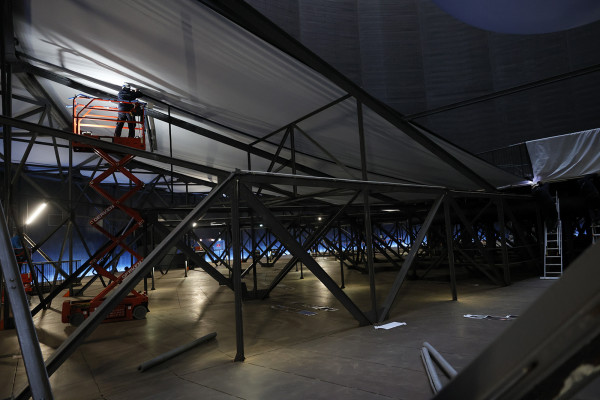 Ein Arbeiter auf einerm Hubwagen fixierte eine Stoffbahn.