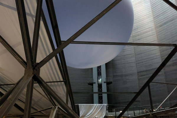 Die riesiege Erdkugel im Hintergrund, Stoffbahnen als Abtrennung zum weiteren Ausstellungsraum im Vordergrund.