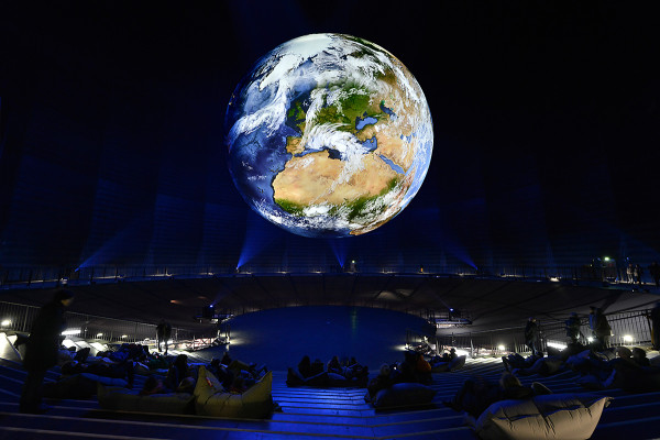 Eine angestrahlte Erdkugel im Inneren des Gasometers