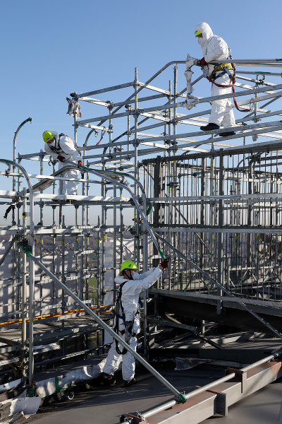 Drei Gerüstbauer bei der Demontage des Fassadengerüsts