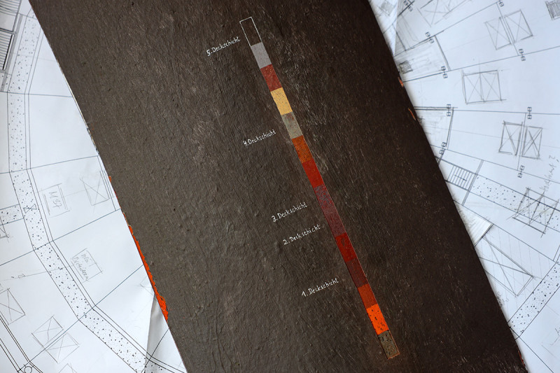 Ein Metallblech mit Freilegungstreppe liegt auf einem Bauplan des Gasomters.