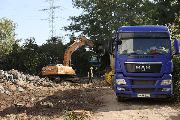 Ein Bagger belädt einen LKW mit Bausschutt