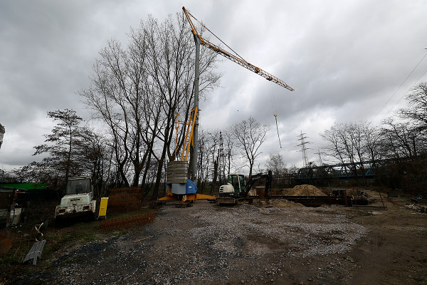 Kran und Bagger vor der Baugrube